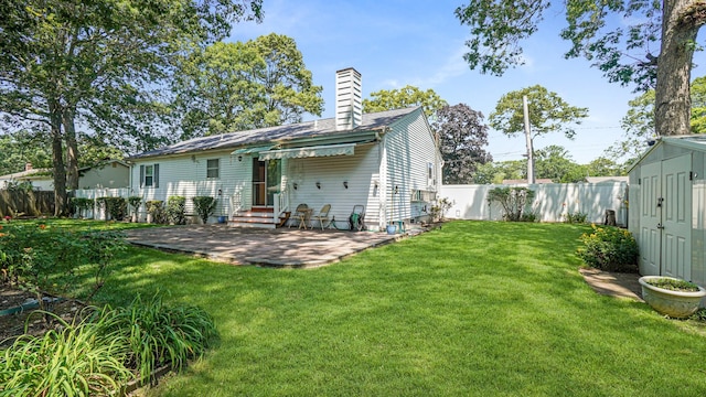 70 Wilson Ave, Mastic Beach, NY 11951 - rear view of property featuring a chimney, a fenced backyard, entry steps, a patio, and a shed