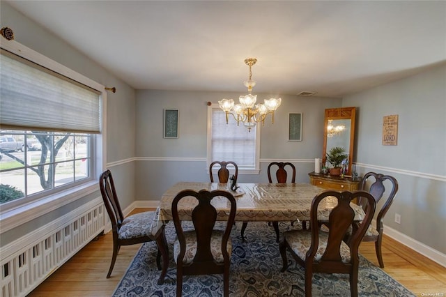121 6th St, Hicksville, NY 11801 - dining room with radiator heating unit, a chandelier, and light wood-style flooring