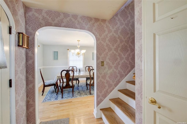121 6th St, Hicksville, NY 11801 - dining space with arched walkways, light wood-type flooring, wallpapered walls, and a chandelier