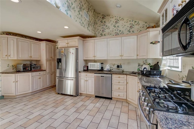 121 6th St, Hicksville, NY 11801 - kitchen with appliances with stainless steel finishes, wallpapered walls, dark stone countertops, recessed lighting, and tasteful backsplash