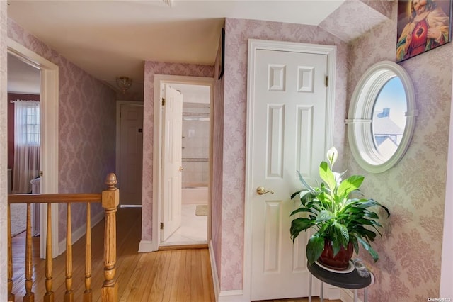 121 6th St, Hicksville, NY 11801 - hallway featuring light wood-type flooring, an upstairs landing, and wallpapered walls