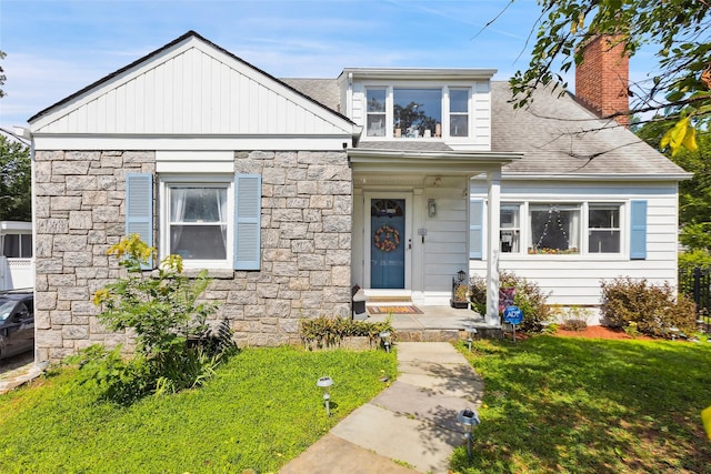 69 Ardell Rd, Bronxville, NY 10708 - view of front of property with stone siding, a front yard, and roof with shingles
