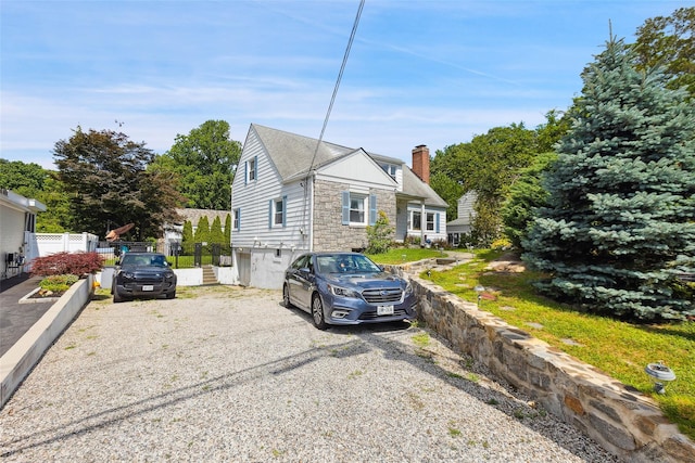 69 Ardell Rd, Bronxville, NY 10708 - view of front of house featuring a chimney, gravel driveway, and stone siding