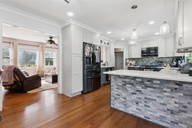 69 Ardell Rd, Bronxville, NY 10708 - kitchen with black fridge, stainless steel microwave, dark wood-style floors, a peninsula, and ornamental molding