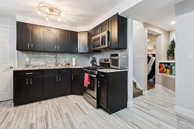 69 Ardell Rd, Bronxville, NY 10708 - kitchen featuring stainless steel appliances, decorative backsplash, light stone counters, and light wood-type flooring