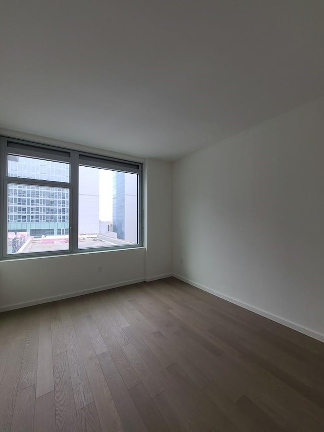 133-27 39th Ave, Flushing, NY 11354 - unfurnished room with wood finished floors and baseboards