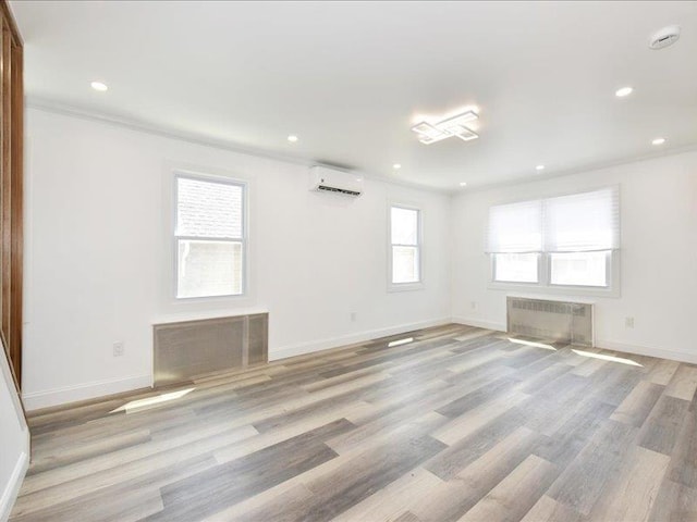 180 Evelyn Rd, Mineola, NY 11501 - empty room featuring radiator heating unit, a wall mounted air conditioner, crown molding, recessed lighting, and light wood finished floors