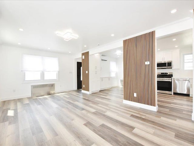 180 Evelyn Rd, Mineola, NY 11501 - unfurnished living room with radiator, light wood finished floors, and recessed lighting