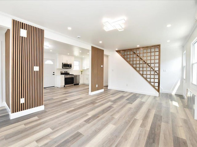 180 Evelyn Rd, Mineola, NY 11501 - unfurnished living room featuring stairway, light wood-style floors, crown molding, healthy amount of natural light, and recessed lighting