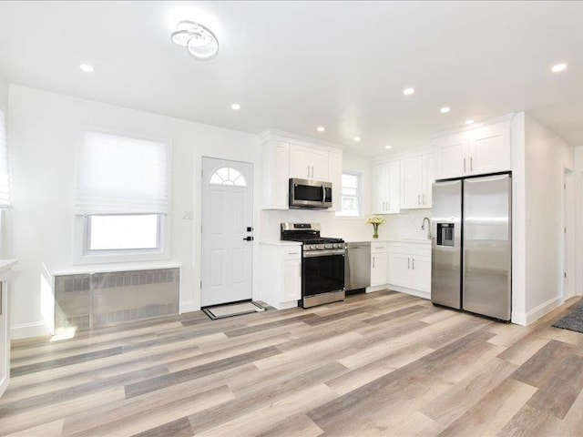 180 Evelyn Rd, Mineola, NY 11501 - kitchen with stainless steel appliances, light wood-style flooring, white cabinetry, and recessed lighting
