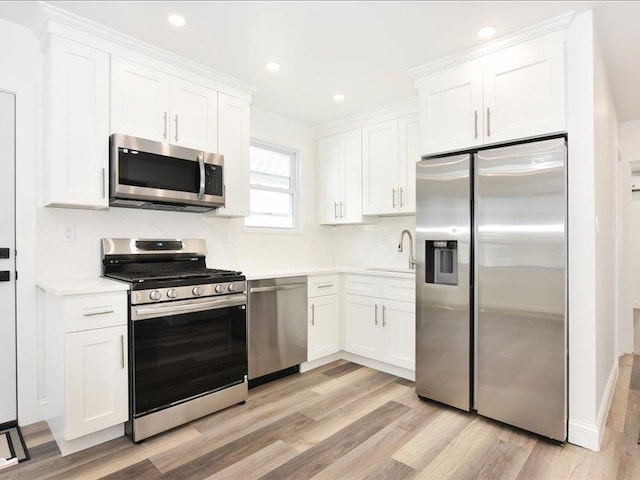 180 Evelyn Rd, Mineola, NY 11501 - kitchen with appliances with stainless steel finishes, light wood-type flooring, white cabinets, light countertops, and recessed lighting