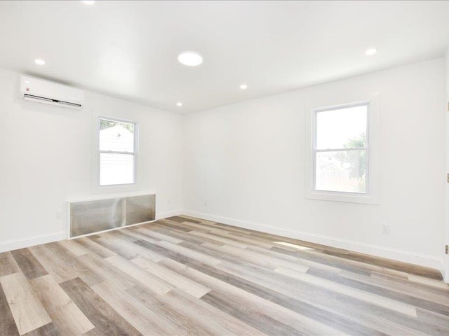 180 Evelyn Rd, Mineola, NY 11501 - empty room featuring a wall unit AC, light wood-type flooring, and recessed lighting
