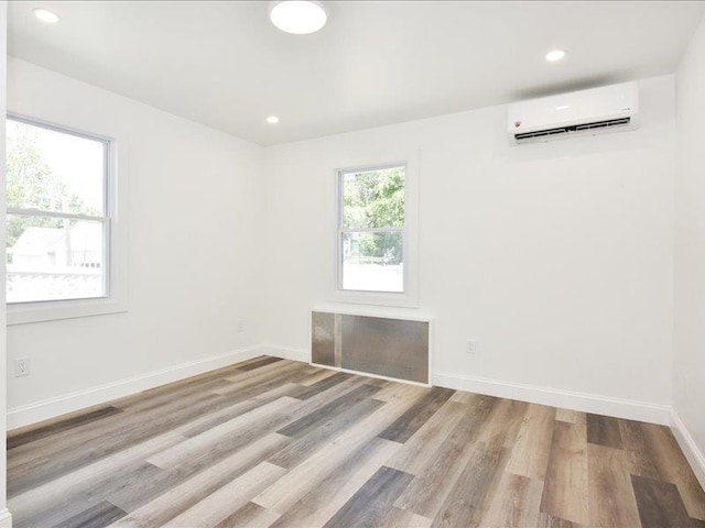 180 Evelyn Rd, Mineola, NY 11501 - spare room with a wall mounted air conditioner, wood finished floors, and recessed lighting