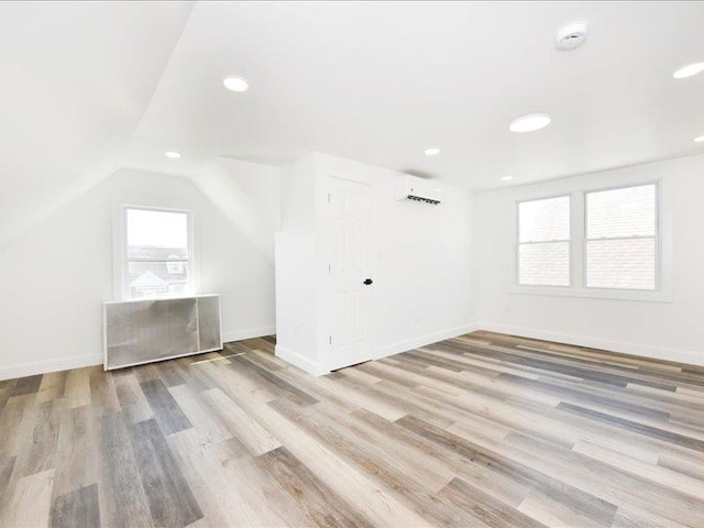 180 Evelyn Rd, Mineola, NY 11501 - additional living space featuring a wall unit AC, light wood-style flooring, recessed lighting, and lofted ceiling