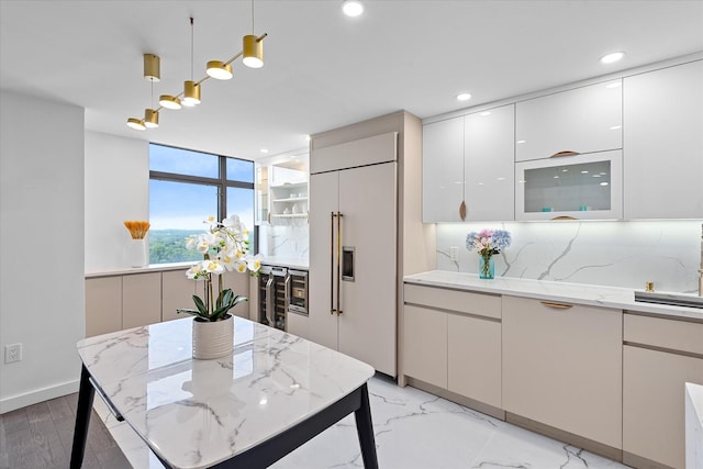 11201 Queens Blvd Unit 18D, Forest Hills, NY 11375 - kitchen featuring paneled built in fridge, wine cooler, hanging light fixtures, modern cabinets, and light stone counters