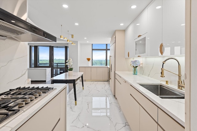 11201 Queens Blvd Unit 18D, Forest Hills, NY 11375 - kitchen with wall chimney exhaust hood, light marble finish floors, recessed lighting, stainless steel gas stovetop, and white cabinetry
