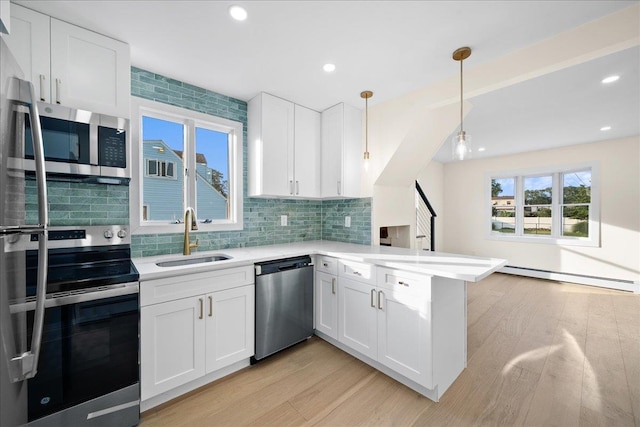 247 N Greene Ave, Lindenhurst, NY 11757 - kitchen featuring stainless steel appliances, a baseboard heating unit, a peninsula, light wood-style floors, and light countertops