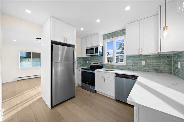247 N Greene Ave, Lindenhurst, NY 11757 - kitchen featuring appliances with stainless steel finishes, baseboard heating, light wood-style floors, light stone countertops, and white cabinets