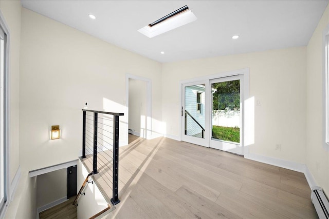 247 N Greene Ave, Lindenhurst, NY 11757 - spare room with baseboard heating, a skylight, light wood finished floors, and recessed lighting