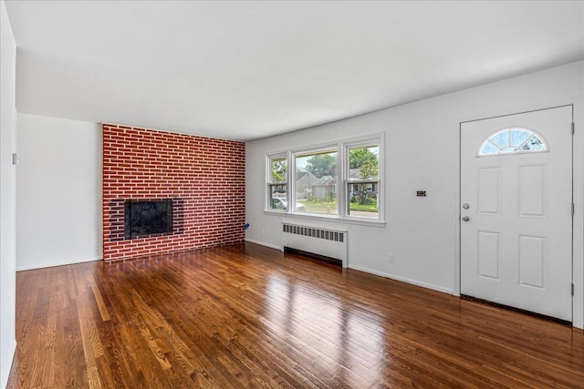 19 Dakota St, Hicksville, NY 11801 - unfurnished living room featuring radiator heating unit, wood finished floors, and a brick fireplace