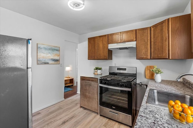 19 Dakota St, Hicksville, NY 11801 - kitchen featuring appliances with stainless steel finishes, under cabinet range hood, light wood-type flooring, light countertops, and brown cabinetry
