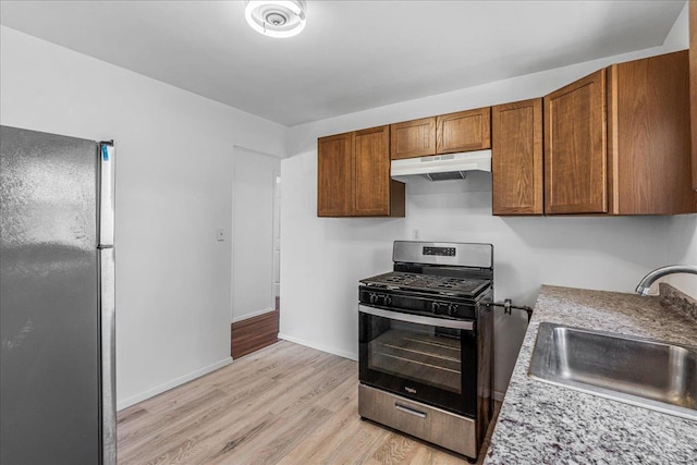 19 Dakota St, Hicksville, NY 11801 - kitchen with stainless steel appliances, under cabinet range hood, light wood finished floors, light countertops, and brown cabinetry