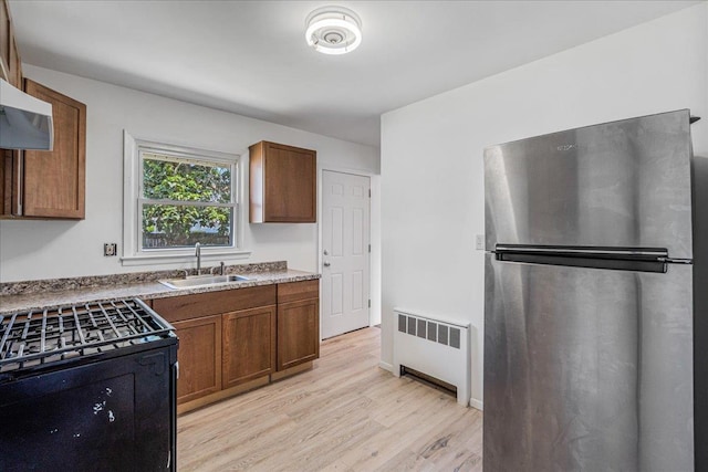 19 Dakota St, Hicksville, NY 11801 - kitchen featuring freestanding refrigerator, radiator, gas stove, light wood finished floors, and brown cabinetry