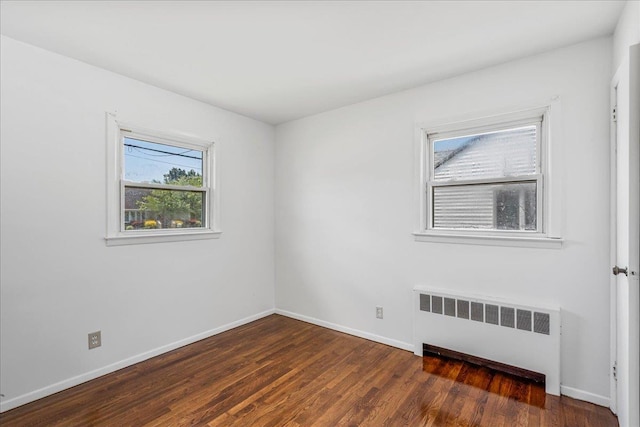 19 Dakota St, Hicksville, NY 11801 - spare room with radiator heating unit, healthy amount of natural light, and wood finished floors
