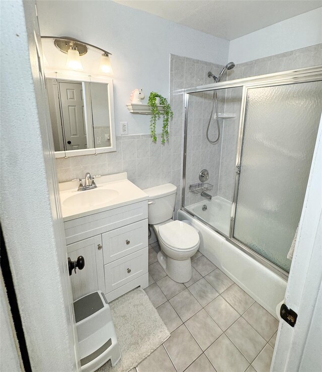 5 Church Ln Unit I, Valley Cottage, NY 10989 - bathroom with bath / shower combo with glass door, vanity, tile patterned floors, and tile walls