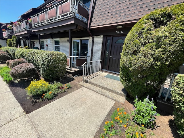 5 Church Ln Unit I, Valley Cottage, NY 10989 - view of exterior entry featuring brick siding, a shingled roof, and mansard roof