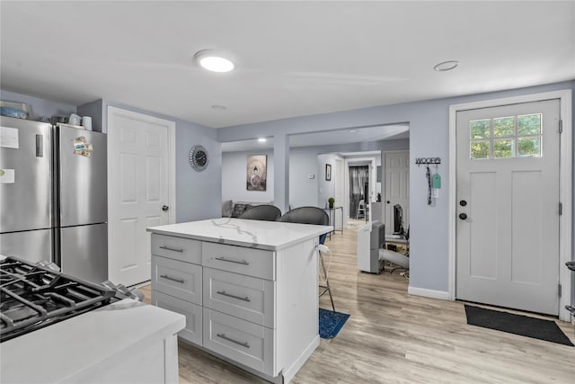 17 Sterling St, Middletown, NY 10940 - kitchen with a kitchen breakfast bar, light wood finished floors, a kitchen island, and freestanding refrigerator