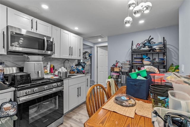 17 Sterling St, Middletown, NY 10940 - kitchen with stainless steel appliances, tasteful backsplash, recessed lighting, light wood-style floors, and white cabinetry
