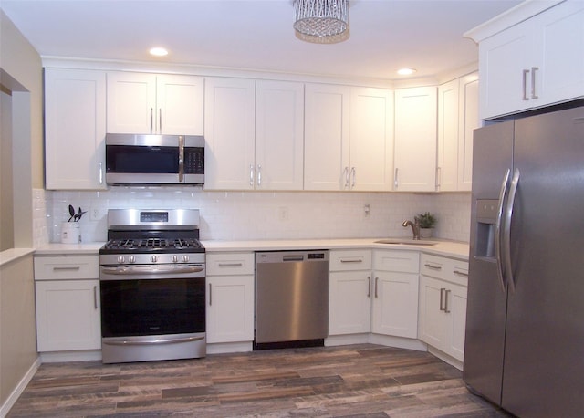 8 Country View Ln, Middle Island, NY 11953 - kitchen featuring stainless steel appliances, white cabinets, light countertops, decorative backsplash, and recessed lighting