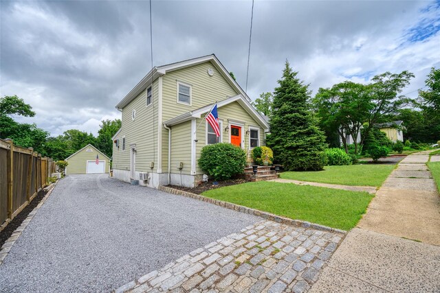 27 Neulist Ave, Port Washington, NY 11050 - view of front of house featuring a detached garage, an outbuilding, and driveway