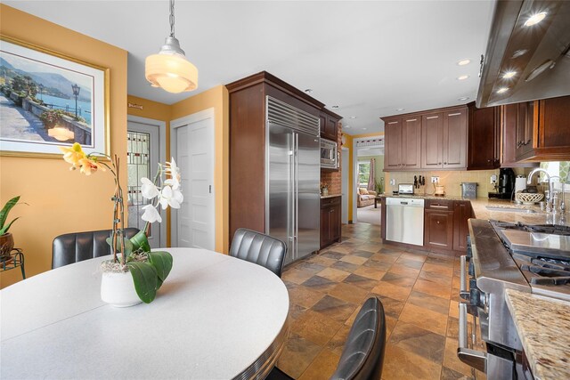 27 Neulist Ave, Port Washington, NY 11050 - kitchen with built in appliances, backsplash, recessed lighting, extractor fan, and hanging light fixtures