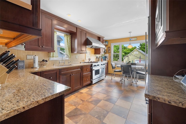 27 Neulist Ave, Port Washington, NY 11050 - kitchen featuring high end stainless steel range oven, exhaust hood, tasteful backsplash, light stone counters, and hanging light fixtures