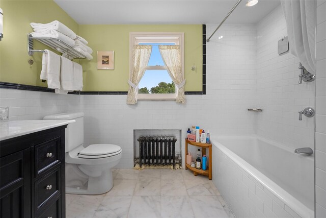 27 Neulist Ave, Port Washington, NY 11050 - bathroom featuring radiator, tile walls, vanity, tiled shower / bath combo, and marble look tile flooring