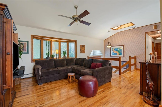 713 Thomas Ave, Baldwin, NY 11510 - living area featuring a skylight, wood walls, a baseboard radiator, light wood finished floors, and vaulted ceiling