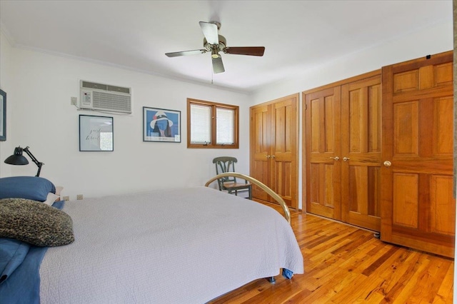 713 Thomas Ave, Baldwin, NY 11510 - bedroom with light wood-type flooring, two closets, a wall mounted air conditioner, and ceiling fan