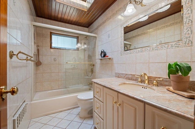 713 Thomas Ave, Baldwin, NY 11510 - bathroom with tile patterned floors, tile walls, vanity, and tub / shower combination