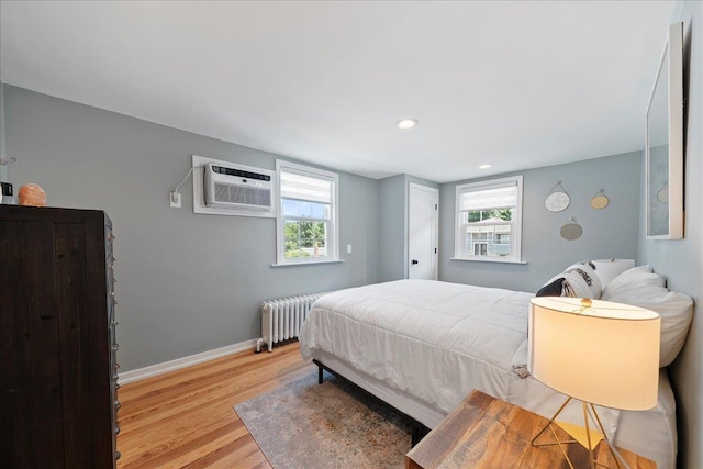 56 Summers St, Oyster Bay, NY 11771 - bedroom featuring a wall unit AC, radiator, light wood-style floors, multiple windows, and recessed lighting