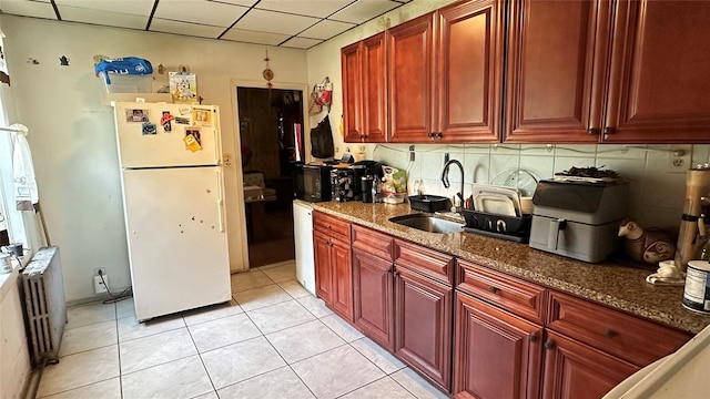 16 Upper Ferndale Rd, Liberty, NY 12754 - kitchen with freestanding refrigerator, radiator heating unit, a drop ceiling, reddish brown cabinets, and dark stone countertops