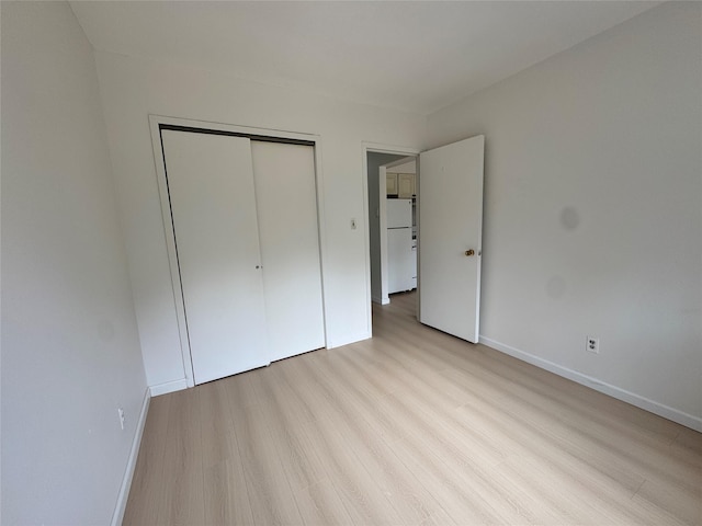 43-53 159th St, Flushing, NY 11358 - unfurnished bedroom featuring freestanding refrigerator, wood finished floors, and a closet