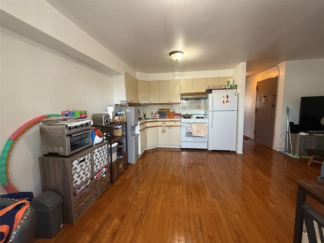 43-53 159th St, Flushing, NY 11358 - kitchen featuring white appliances, light countertops, dark wood-type flooring, under cabinet range hood, and tasteful backsplash