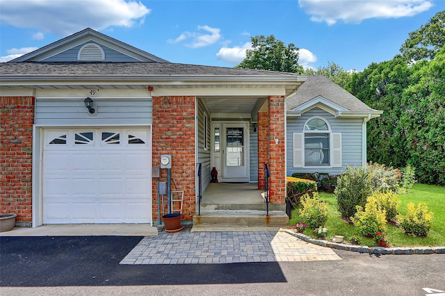 49 Primrose Ln, North Babylon, NY 11703 - view of front facade with a garage, asphalt driveway, a shingled roof, and brick siding