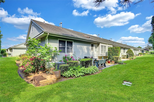 49 Primrose Ln, North Babylon, NY 11703 - rear view of property featuring a patio, a lawn, and roof with shingles