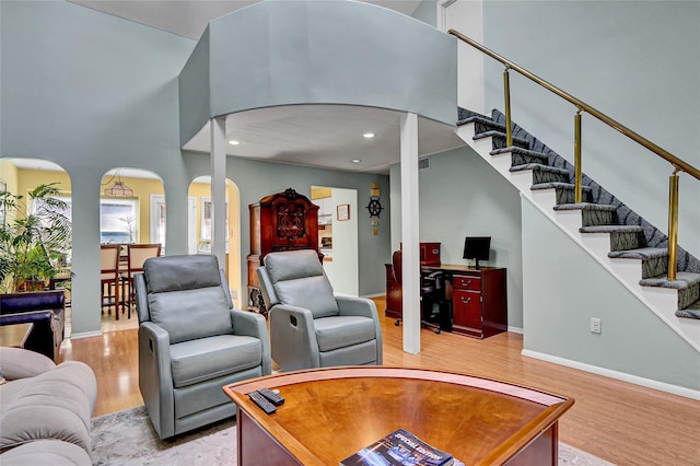 49 Primrose Ln, North Babylon, NY 11703 - living area featuring arched walkways, light wood finished floors, stairway, recessed lighting, and a high ceiling