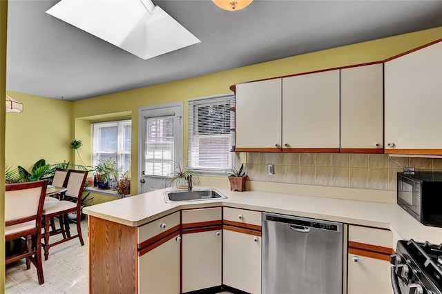 49 Primrose Ln, North Babylon, NY 11703 - kitchen featuring stainless steel dishwasher, gas range oven, black microwave, light countertops, and a peninsula