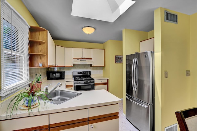 49 Primrose Ln, North Babylon, NY 11703 - kitchen with appliances with stainless steel finishes, a skylight, under cabinet range hood, open shelves, and decorative backsplash