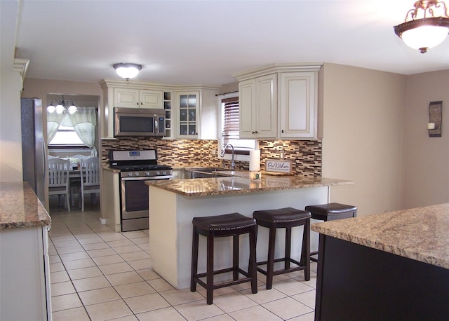 13 Lark Dr, Centereach, NY 11720 - kitchen featuring appliances with stainless steel finishes, healthy amount of natural light, light tile patterned floors, and backsplash